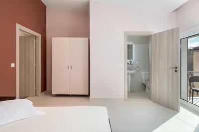 a bedroom with a white bed and a bathroom at M City Apartments 100m from the beach in Chania Town