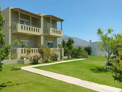 a house with a green yard and a walkway at Argilos Apartments in Frangokastello