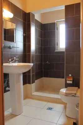 a bathroom with a sink and a tub and a toilet at Argilos Apartments in Frangokastello