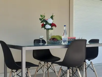 a table with four chairs and a vase with flowers at House escape in Chania Town