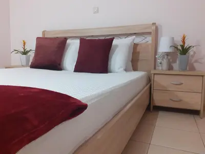 a bedroom with a large bed with red and white pillows at House escape in Chania Town