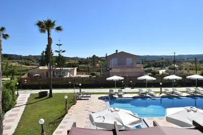 a swimming pool with umbrellas and a resort at Odos Oneiron Tavronitis Bay in Tavronitis