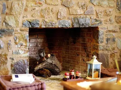 a stone fireplace with a brick wall with a lantern at Holiday home with pool in Kalamítsion Alexándrou