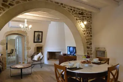 a living room with a table and a fireplace at Villa Christini a luxury villa with amazing views in Tzitzifés