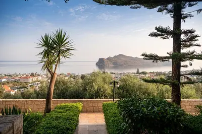 a garden with trees and a view of the ocean at Caldera Village in Agia Marina Nea Kydonias