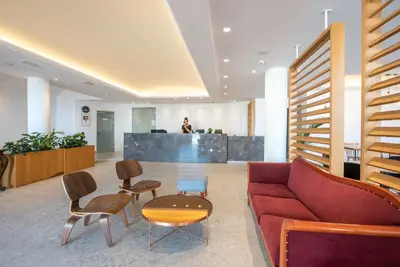 a lobby with a red couch and chairs and a counter at Caldera Village in Agia Marina Nea Kydonias