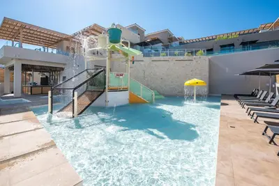 a water park with a water slide in a building at Caldera Village in Agia Marina Nea Kydonias