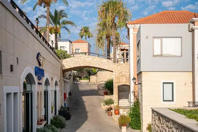 an alley between two buildings with a bridge at Caldera Village in Agia Marina Nea Kydonias