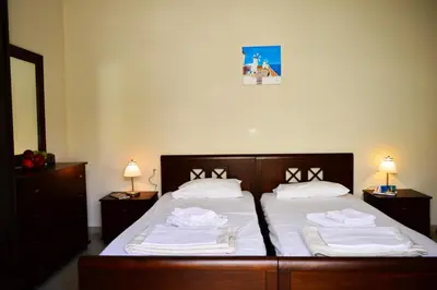 a bedroom with two beds with white sheets and towels at Villa Spilia Homeleader in Spiliá
