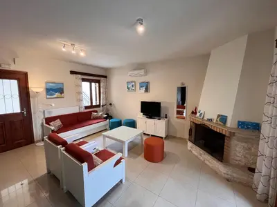 a living room with a couch and a fireplace at Villa Spilia Homeleader in Spiliá