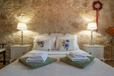 a bedroom with a white bed with towels on it at Private Stone villa-Pool and Maountain view in Karés