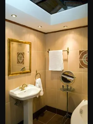 a bathroom with a sink and a toilet and a mirror at Private Stone villa-Pool and Maountain view in Karés
