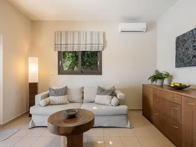 a living room with a couch and a table at Villa Hibiscus in Spiliá