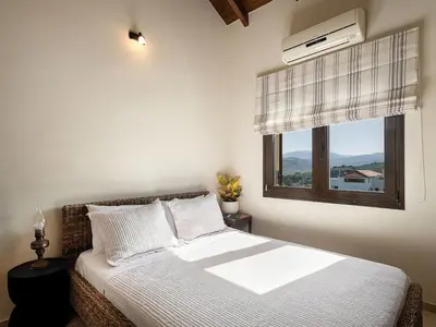 a bedroom with a white bed and a window at Villa Hibiscus in Spiliá