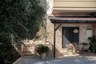 a patio with a table and chairs in front of a building at Villa Hibiscus in Spiliá