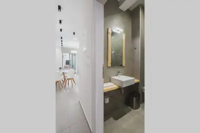 a white bathroom with a sink and a mirror at Peris 1 - Central Apt near Old Town with Parking in Chania Town