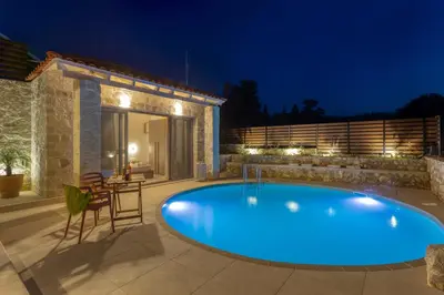 a swimming pool in the middle of a yard at night at Canna Villa in Vamos