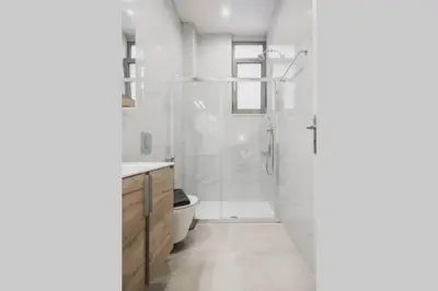 a white bathroom with a shower and a toilet at Peris 2 - Central Apt near Old Town - AC, Washer in Chania Town