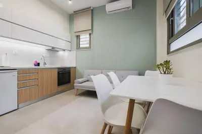 a kitchen and dining room with a white table and chairs at Peris 2 - Central Apt near Old Town - AC, Washer in Chania Town