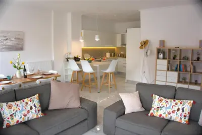 a living room with two couches and a kitchen at New Big Modern City Center Apartment in Chania Town