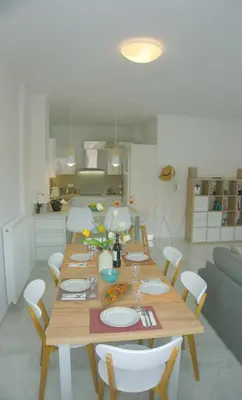 a wooden table in a living room with a kitchen at New Big Modern City Center Apartment in Chania Town