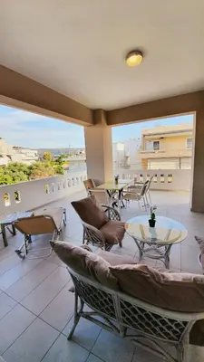 a room with a balcony with a piano and tables at New Big Modern City Center Apartment in Chania Town