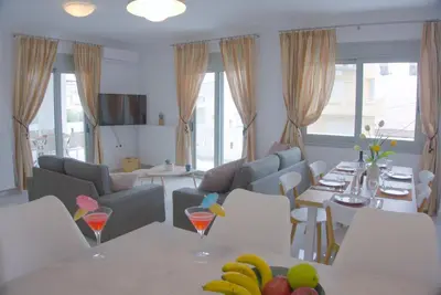 a living room with a couch and a table with fruit at New Big Modern City Center Apartment in Chania Town