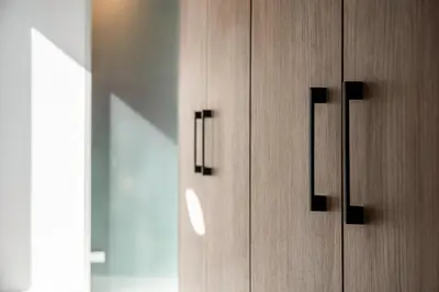 a wooden cabinet with black handles in a room at Morum City Hotel Chania in Chania Town