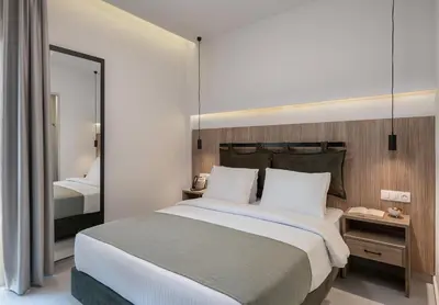 a bedroom with a large bed and a mirror at Morum City Hotel Chania in Chania Town