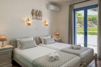 two beds in a room with a window at Pano Stalos Villas in Stalos
