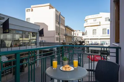 a table with a plate of food on a balcony at MIRMA CITY Old Town in Chania Town