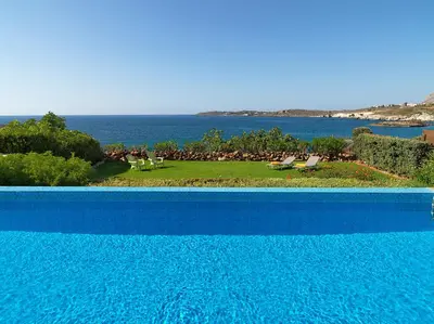 a blue swimming pool with a view of the ocean at Villa Anemos by Estia in Kalathas