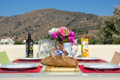 a table with a sandwich and a bottle of wine and flowers at Villa Nopigia Homeleader in Nopíyia