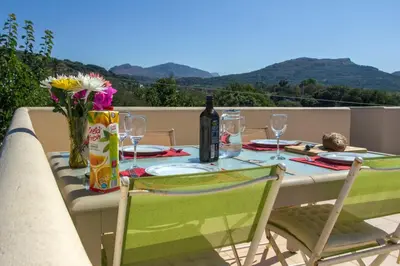 a table with a bottle of wine and two chairs at Villa Nopigia Homeleader in Nopíyia