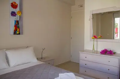 a bedroom with a bed and a dresser with a mirror at Villa Nopigia Homeleader in Nopíyia