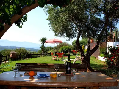 a table with a bottle of wine and glasses at Villa Papoura Homeleader in Delimanolianá