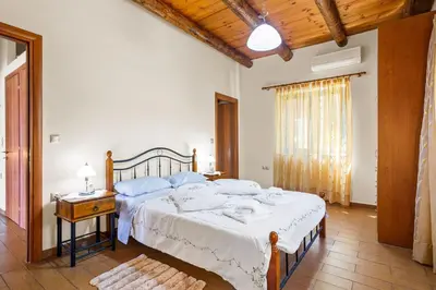 a bedroom with a large bed with a white blanket at Kambos Horizon & Paradise Villas in Kissamos