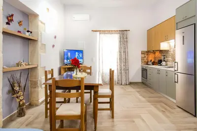 a kitchen with a table and chairs in a room at Eliana's Stone House in Benoudhianá