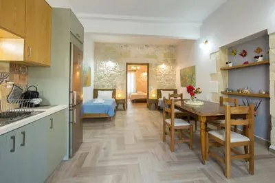 a kitchen and dining room with a table and chairs at Eliana's Stone House in Benoudhianá