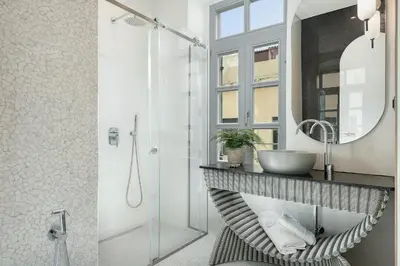 a bathroom with a sink and a shower with a mirror at Malmo Historic Hotel in Chania Town