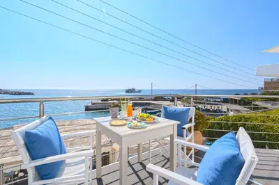 a white table and chairs on a balcony with the ocean at Veranta Luxury Suite in Khóra Sfakíon