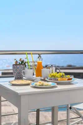 a white table with plates of food on it at Veranta Luxury Suite in Khóra Sfakíon