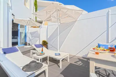 a patio with a table and chairs and an umbrella at FantaSea Luxury Suite in Khóra Sfakíon