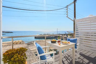 a table and chairs on a balcony overlooking the ocean at FantaSea Luxury Suite in Khóra Sfakíon