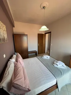 a large bed in a bedroom with a light at Girogiali Apts in Kissamos