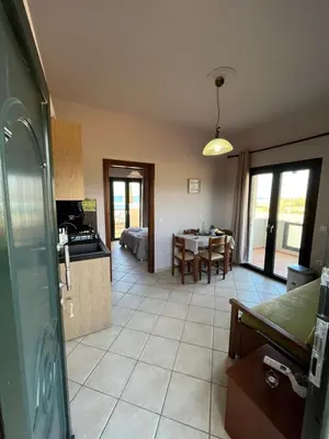 a kitchen and a living room with a table at Girogiali Apts in Kissamos