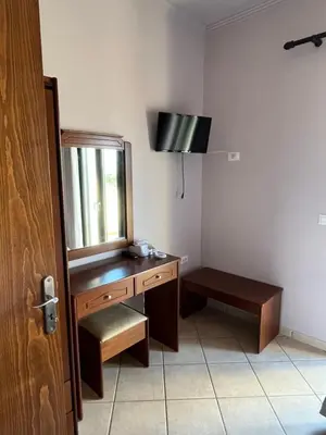 a bathroom with a wooden dresser and a mirror at Girogiali Apts in Kissamos