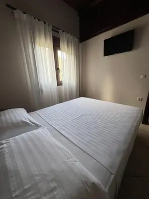 a large white bed in a bedroom with a window at Serenity Resort in Vrísai