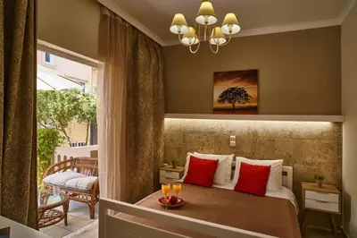 a bedroom with a bed with red pillows and a balcony at Natasha's Luxury apartment by the sea in Galatás