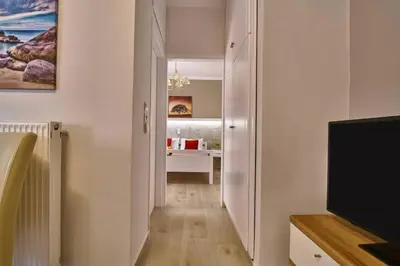 a hallway with a living room with a flat screen tv at Natasha's Luxury apartment by the sea in Galatás